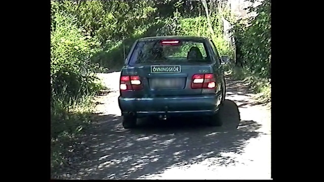 Video Reference N1: Land vehicle, Vehicle, Car, Vehicle registration plate, Mode of transport, Mini suv, Automotive exterior, City car, Outdoor, Driving, Street, Riding, Truck, Traveling, Road, Small, Black, Forest, Red, Parked, Yellow, Bus, Man, Mirror, Tree, Text, Wheel, Auto part, Way, Tire