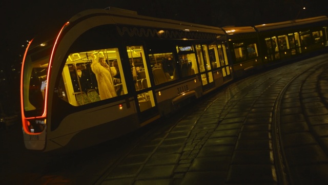 Video Reference N0: yellow, public transport, night, mode of transport, transport, light, rapid transit, train, darkness, lighting