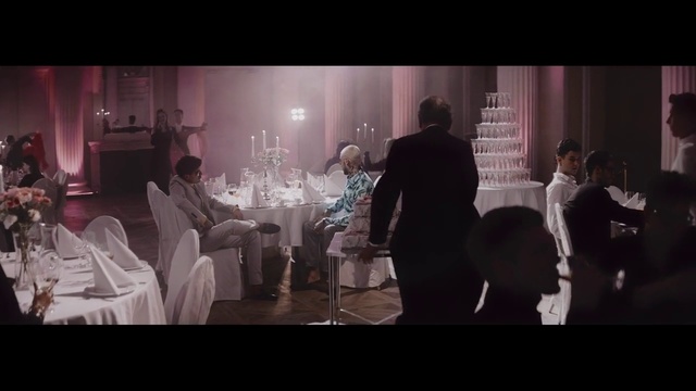 Video Reference N1: Photograph, Snapshot, Event, Fun, Design, Darkness, Function hall, Photography, Gentleman, Conversation, Person, Man, Indoor, Table, Front, Photo, Looking, Standing, Woman, Wine, People, Glasses, Group, Screen, Room, Holding, Large, Display, Cake, White, Wedding, Wedding dress, Clothing, Bride, Candle