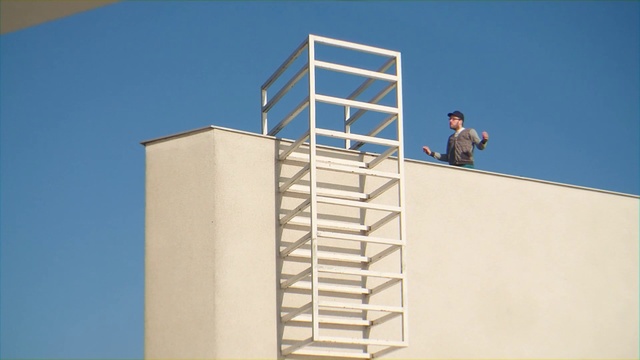 Video Reference N3: Stairs, Architecture, Ladder, Material property, Facade, Building, Window, Daylighting, House, Balcony, Man, Person, Riding, Jumping, Standing, Shirt, Doing, Large, Trick, Air, Board, White, Holding, Clock, Ramp, Tower, Flying, Sky, Text, Clothing
