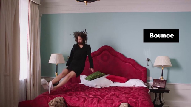 Video Reference N1: Bedroom, Bed, Bed sheet, Room, Furniture, Comfort, Bed frame, Mattress, Bedding, Textile, Indoor, Red, Window, Looking, Woman, Small, Sitting, Table, Standing, Hotel, Black, Green, Man, Young, Large, Cat, Wall, Clothing, Person
