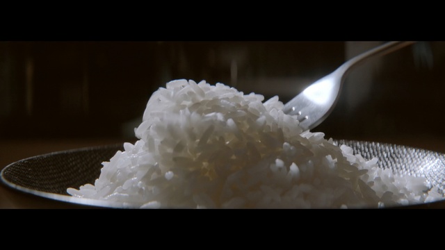 Video Reference N3: Steamed rice, White rice, Jasmine rice, Food, Rice, Dish, Fleur de sel, Basmati, Glutinous rice, Ingredient, Table, Plate, Indoor, Cake, Sitting, Dessert, White, Fork, Piece, Cream, Black, Desert, Chocolate, Spoon, Knife, Covered, Glass, Holding