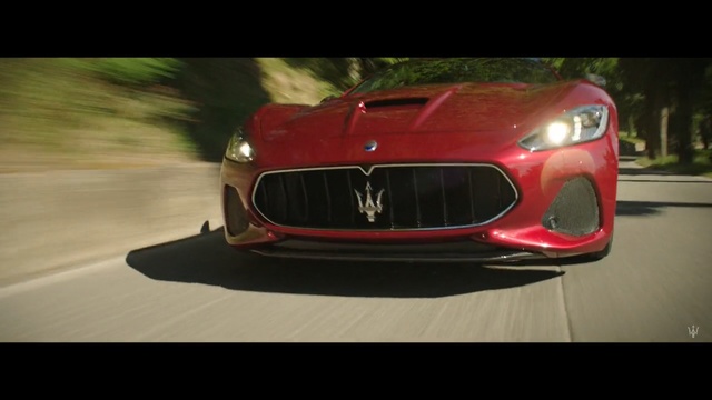 Video Reference N1: car, vehicle, auto, automobile, speed, sports car, transportation, wheel, fast, motor vehicle, drive, grille, transport, luxury, motor, bumper, headlight, sports, grate, race, sport, tire, power, driving, style, shiny, modern, design, road, expensive, chrome, barrier, spoiler, wheels, Person