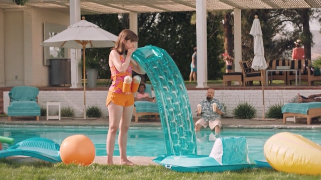 Video Reference N1: Aqua, Fun, Leisure, Games, Recreation, Inflatable, Backyard, Play, Vacation, Swimming pool, Building, Outdoor, Woman, Girl, Grass, Young, Lady, Table, Playing, Umbrella, Front, Green, Orange, Standing, Female, Riding, Pool, Water, Holding, Ball, Frisbee, Blue, Court, Jumping, Large, Surfing, White, Beach, Game, Soccer, Board, Man, Doing, Swimming, Person, Clothing, Playground, Swimwear, Toddler