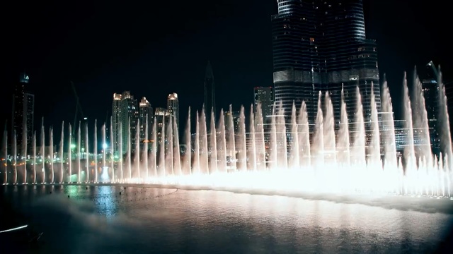 Video Reference N3: Fountain, Water, City, Reflection, Human settlement, Water feature, Night, Metropolis, Metropolitan area, Skyline, Person