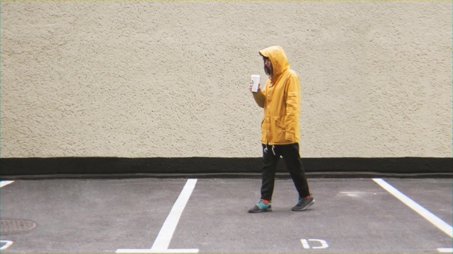 Video Reference N2: Standing, Outerwear, Street fashion, Person, Sport, Game, Road, Building, Outdoor, Woman, Yellow, Holding, Young, Court, Man, Ball, Girl, Playing, Phone, Walking, Talking, Player, Air, Footwear, Clothing, Athletic game, Trousers, Jeans, Coat