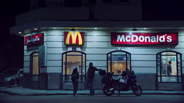 Video Reference N12: Building, Night, Signage, Vehicle, Automotive lighting, Advertising, Facade, Fast food restaurant, Street, Electronic signage, Person