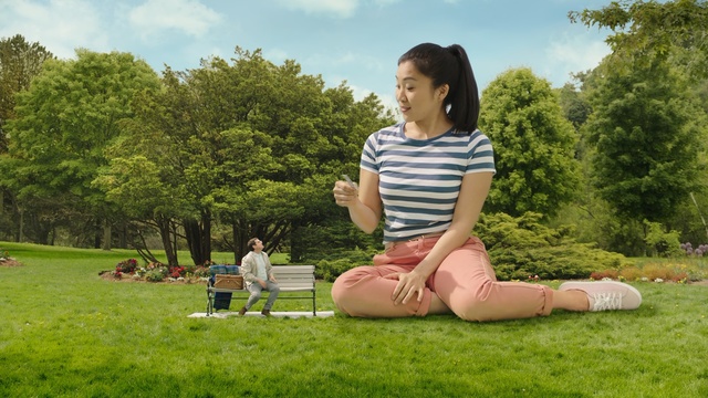 Video Reference N1: People in nature, Grass, Sitting, Lawn, Summer, Leisure, Spring, Fun, Meadow, Tree, Outdoor, Person, Young, Park, Woman, Girl, Field, Grassy, Boy, Man, Green, Bench, Holding, Little, Large, Playing, White, Shirt, Laying, Red, People, Frisbee, Game, Sky, Clothing, Smile, Human face, Footwear, Plant