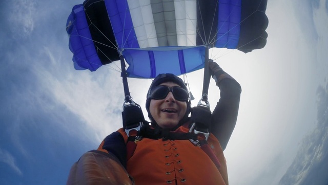 Video Reference N15: Sky, Smile, Outerwear, Blue, Cloud, Sleeve, Happy, Travel, Sunglasses, Parachuting