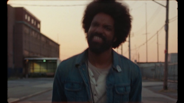 Video Reference N2: Hair, Outerwear, Hairstyle, Smile, Sky, Jheri curl, Beard, Jaw, Flash photography, Standing