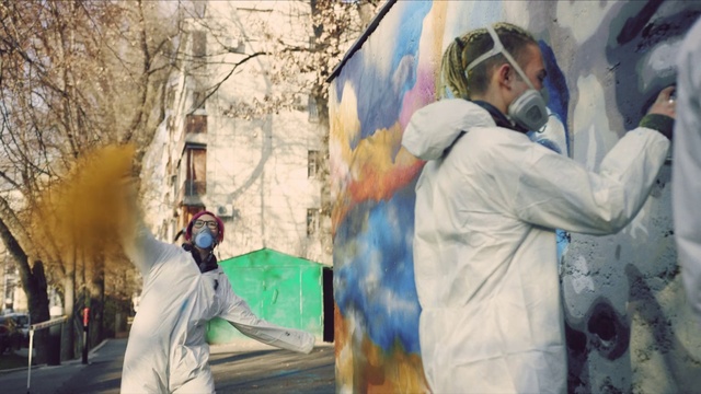 Video Reference N6: Daytime, Coat, Artist, Headgear, Art, Jacket, Wall, Tree, Event, Painting