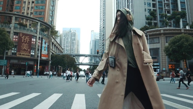 Video Reference N2: Building, Daytime, Infrastructure, Street fashion, Road surface, Standing, Sky, Overcoat, Trench coat, Sidewalk