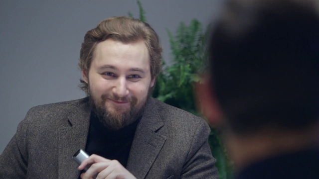 Video Reference N9: Forehead, Smile, Beard, Flash photography, Jaw, Coat, Gesture, Mobile phone, Happy, Facial hair