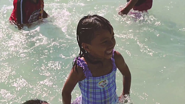 Video Reference N5: Water, Facial expression, Smile, Body of water, Happy, People on beach, Fun, Leisure, Red, Toddler